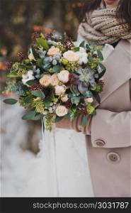 Original bouquet of flowers in the hands of women against the winter landscape.. Beautiful winter bouquet of flowers in the hands of the bride 827.. Beautiful winter bouquet of flowers in the hands of the bride 82