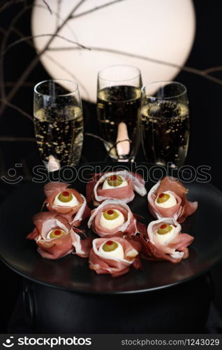 Original Halloween snacks. Eyeballs cooked from ham with mozzarella, olives stuffed with red pepper