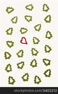 Ornamental heart between fir-trees on white background representing Christmas.