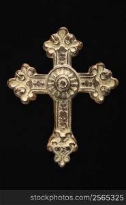 Ornamental religious cross against black background.