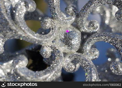 Ornamental silver snowflake glittering on fresh white snow.