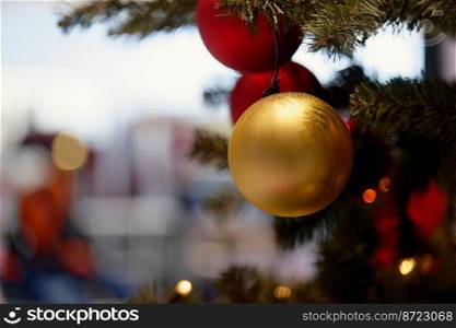 Ornaments and lights on the decorated Christmas tree.   Christmas decorations on the holiday. Colorful balls garland glowing l&s and red berries on the branches are sprinkled with snow.Festive traditional seamless background for the New Year