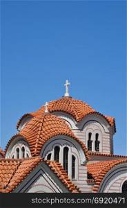 Orthodox church exterior detail of dome with cross and windows.