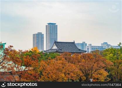 Osaka temple pagoda with red maple leaves or fall foliage with branches in colorful autumn season in Osaka City, Kansai. Trees in Japan. Architecture landscape background.