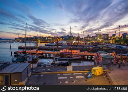 Oslo port with boat and skyline at night in Oslo city, Norway.