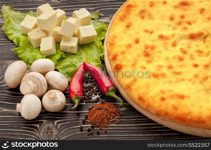 Ossetian cuisine. Kozodjin meat pie and vegetables on wood.