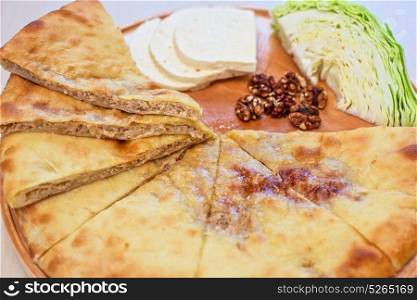 ossetian pie on a white. ossetian pie with cabbage and nuts on a white background