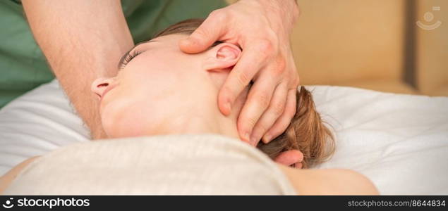 Osteopath doing massage on the female head in rehabilitation clinic center. Osteopath doing massage on the female head in rehabilitation clinic center.