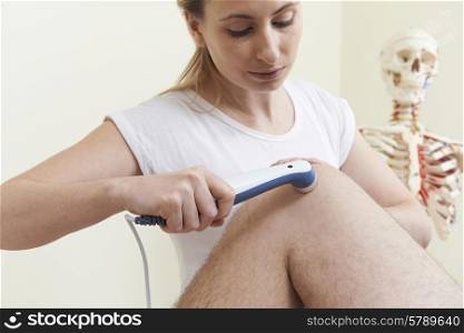 Osteopath Giving Male Client Ultrasound Treatment