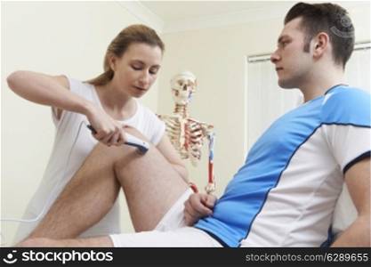 Osteopath Giving Male Client Ultrasound Treatment