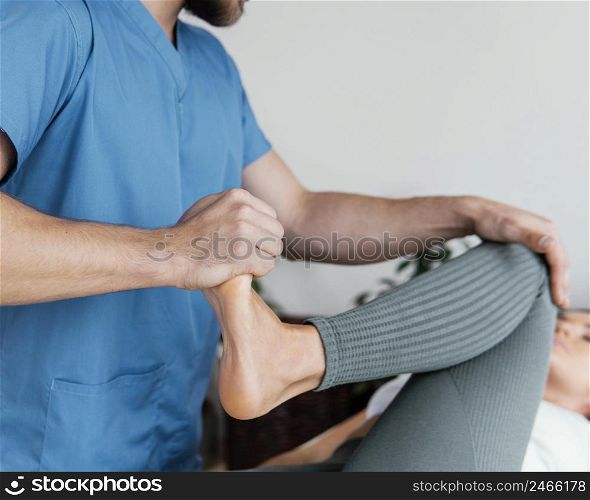 osteopathic doctor checking female patient s leg movement