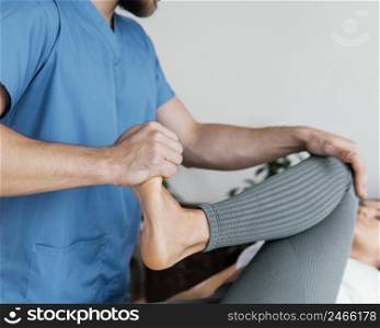 osteopathic doctor checking female patient s leg movement