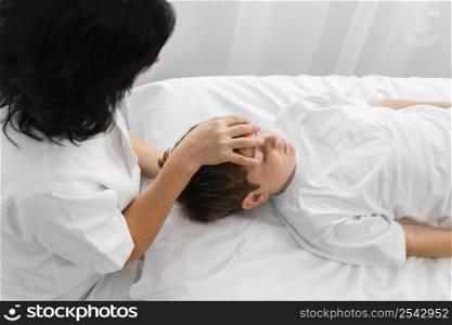 osteopathist treating boy by massaging his head