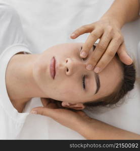 osteopathist treating patient by massaging her face