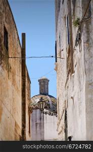 Ostuni cityscape. Ostuni lane in the Old Town (the White City) with a dome in the background, Puglia, Italy