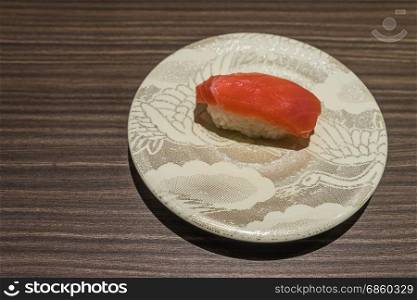 Otoro Tuna sushi, Japanese food raw fish on top of rice in white dish on wooden table