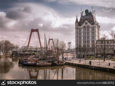 Oudehaven Harbor with historical houseboats with the White House. Witte Huis and Willemsbrug Bridge in the background - Rotterdam, Netherlands. View of Oudehaven Harbor, Rotterdam, The Netherlands