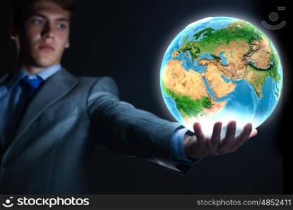 Our Earth planet. Young businessman holding Earth planet in hand. Elements of this image are furnished by NASA