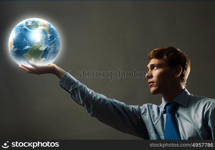 Our Earth planet. Young businessman holding Earth planet in hand. Elements of this image are furnished by NASA