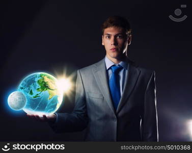 Our Earth planet. Young businessman holding Earth planet in hand. Elements of this image are furnished by NASA