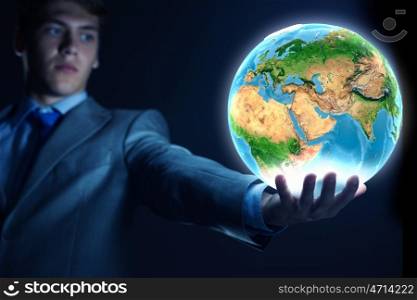 Our Earth planet. Young businessman holding Earth planet in palm. Elements of this image are furnished by NASA