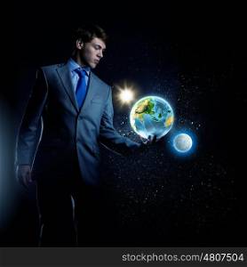 Our Earth planet. Young businessman holding Earth planet in palm. Elements of this image are furnished by NASA