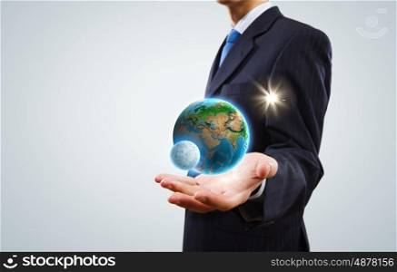 Our home planet. Close up of businessman holding Earth planet in palm. Elements of this image are furnished by NASA
