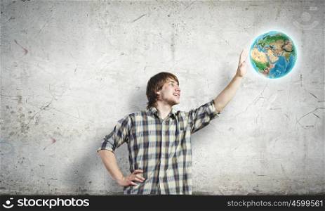 Our home. Young man touching image of Earth planet. Elements of this image are furnished by NASA