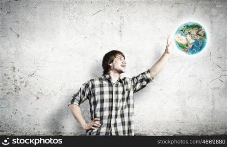 Our home. Young man touching image of Earth planet. Elements of this image are furnished by NASA