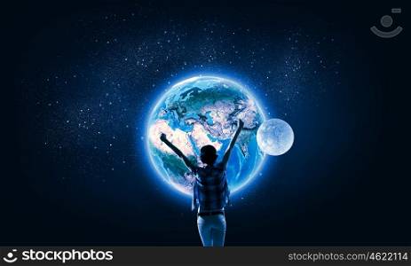 Our universe. Back view of girl with hands up looking at planets. Elements of this image are furnished by NASA
