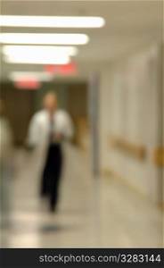 Out of focus doctor walking down hospital hallway.