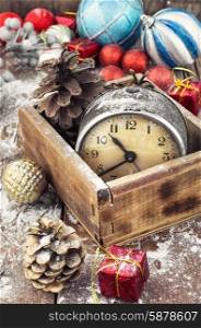 outdated watch in wooden box on the background of Christmas decorations and pine cones.