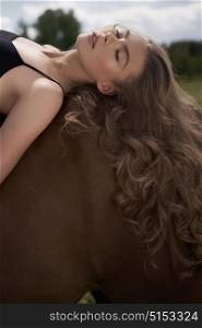 Outdoor art fashion photo of beautiful young lady with horse.