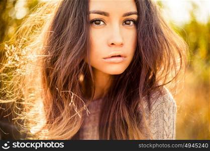 Outdoor atmospheric fashion photo of young beautiful lady. Brown hair and eyes. Warm autumn. Warm spring