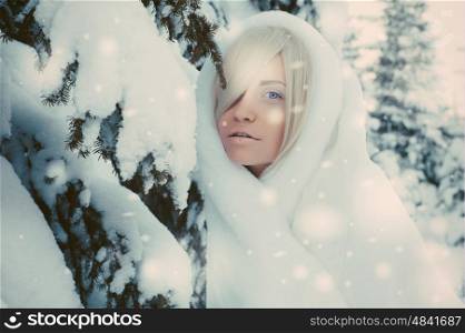 Outdoor atmospheric fashion photo of young beautiful lady in winter forest. Fur coat. Cold weather. Snowflakes
