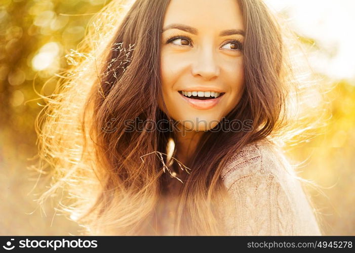 Outdoor atmospheric lifestyle photo of young beautiful lady. Brown hair and eyes. Warm autumn. Warm spring