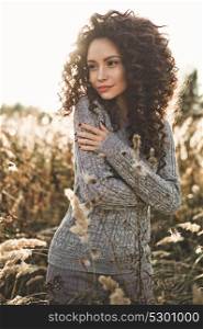 Outdoor atmospheric lifestyle photo of young beautiful lady. Brown hair and eyes. Warm fall. Autumn vibes. Softness, warmth and comfort