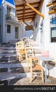 Outdoor cafe on a street of typical greek traditional village in Greece. Coffee on table for breakfast. Outdoor cafe on a street of typical greek traditional village in Greece.