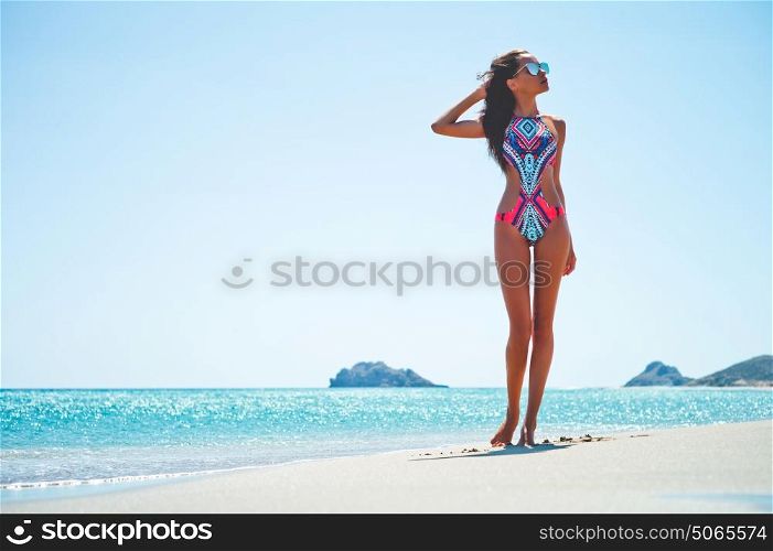 Outdoor fashion photo of beautiful happy slender woman at sea. Beach travel. Summer vibes