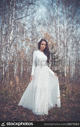 Outdoor fashion photo of young beautiful lady in a birch forest