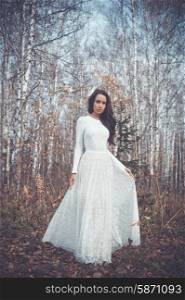Outdoor fashion photo of young beautiful lady in a birch forest