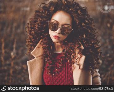 Outdoor fashion photo of young beautiful lady in autumn landscape. Beige coat, knitted sweater, wine lipstick. Fashion lookbook. Warm Autumn. Warm Spring