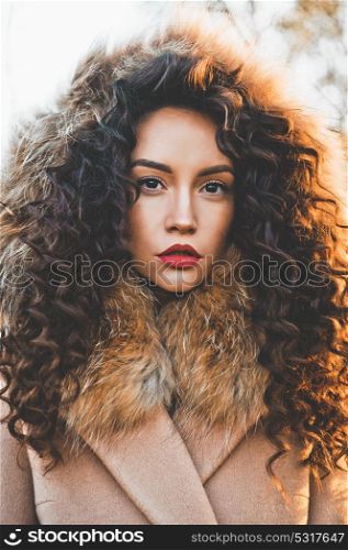 Outdoor fashion photo of young beautiful lady in autumn landscape. Beige coat, fur collar, wine lipstick. Fashion lookbook. Warm Autumn. Warm winter