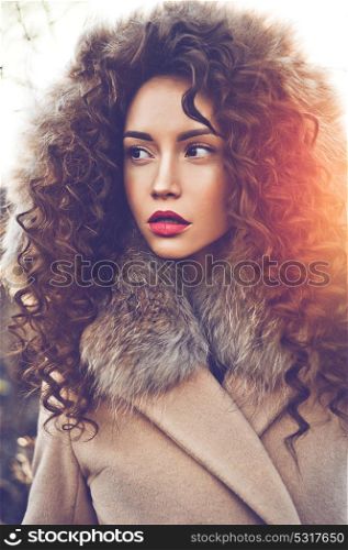Outdoor fashion photo of young beautiful lady in autumn landscape. Beige coat, fur collar, wine lipstick. Fashion lookbook. Warm Autumn. Warm winter