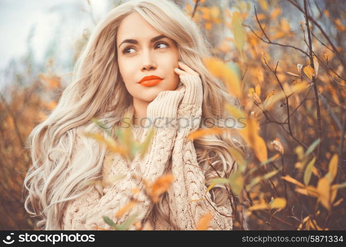 Outdoor fashion photo of young beautiful lady surrounded autumn leaves