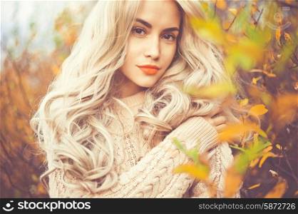Outdoor fashion photo of young beautiful lady surrounded autumn leaves