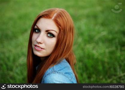 Outdoor fashion portrait of beautiful sensual red haired woman in jeans clothes with long hair.