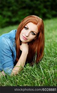 Outdoor fashion portrait of beautiful sensual red haired woman in jeans clothes with long hair.