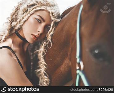 Outdoor fashion portrait of beautiful young girl with brown horse. Hippie style. Summer vibes. Autumn season