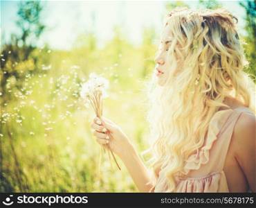 Outdoor fashion portrait of romantic blonde with dandelions